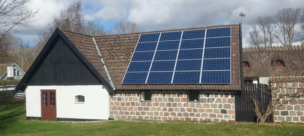 ein Haus mit einem Solarpanel auf dem Dach